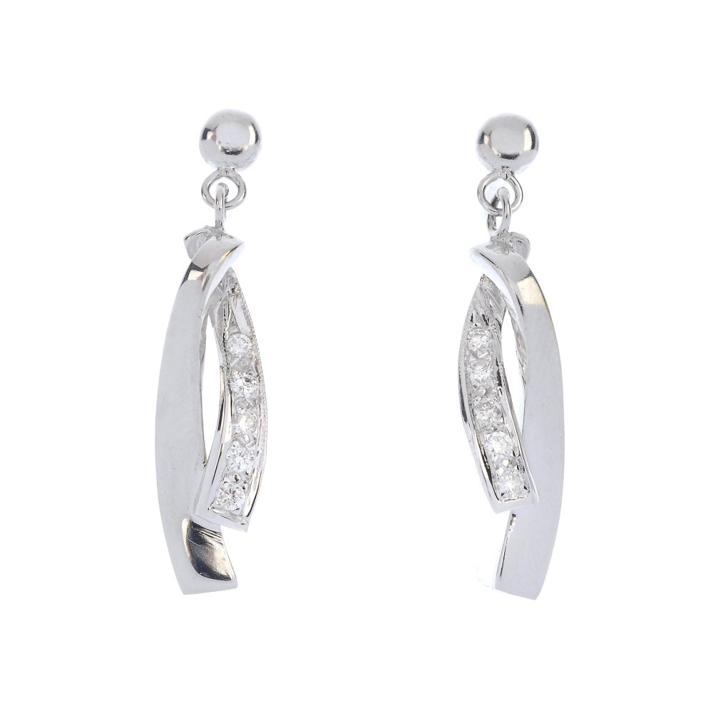 A pair of 14ct gold diamond ear pendants.: A pair of 14ct gold diamond ear pendants. Each designed as a slightly graduated brilliant-cut diamond curved line, to the crossover tapered bar and circular-shape surmount. Estimated total diamond wei