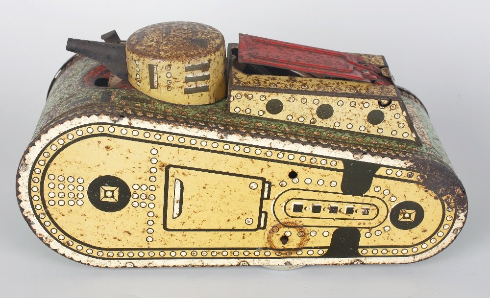 A box containing a Marx tinplate clockwork tank etc.: A box containing a Marx tinplate clockwork tank, the upper housing with concealed soldier figure, a 'Dancing Charlie' printed cardboard novelty toy in original packaging, Charlie Chaplin 'Gold Rush' t