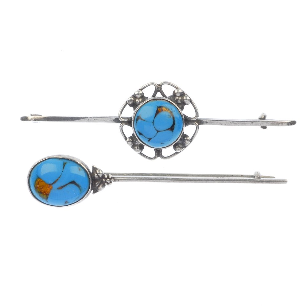 BERNARD INSTONE (attributed to) - two glass brooches.: BERNARD INSTONE (attributed to) - two glass brooches, each designed with a blue and golden glass cabochon, to the foliate surround and accent. Marks to indicate silver. Lengths 6.6 and 7.1cms. Weight