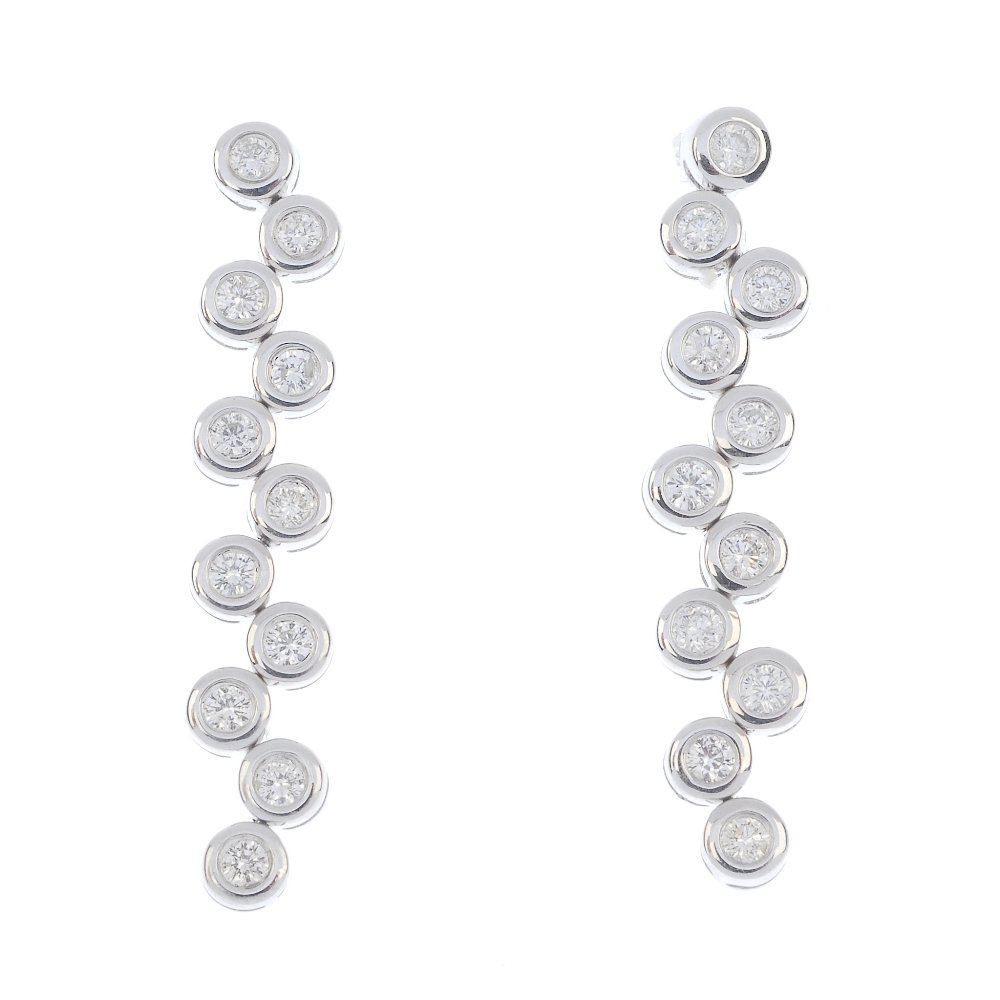 A pair of 18ct gold diamond earrings.: A pair of 18ct gold diamond earrings. Each designed as a brilliant-cut diamond collet staggered line. Estimated total diamond weight 0.85ct. Hallmarks for London. Length 3.3cms. Weight 5.1gms.