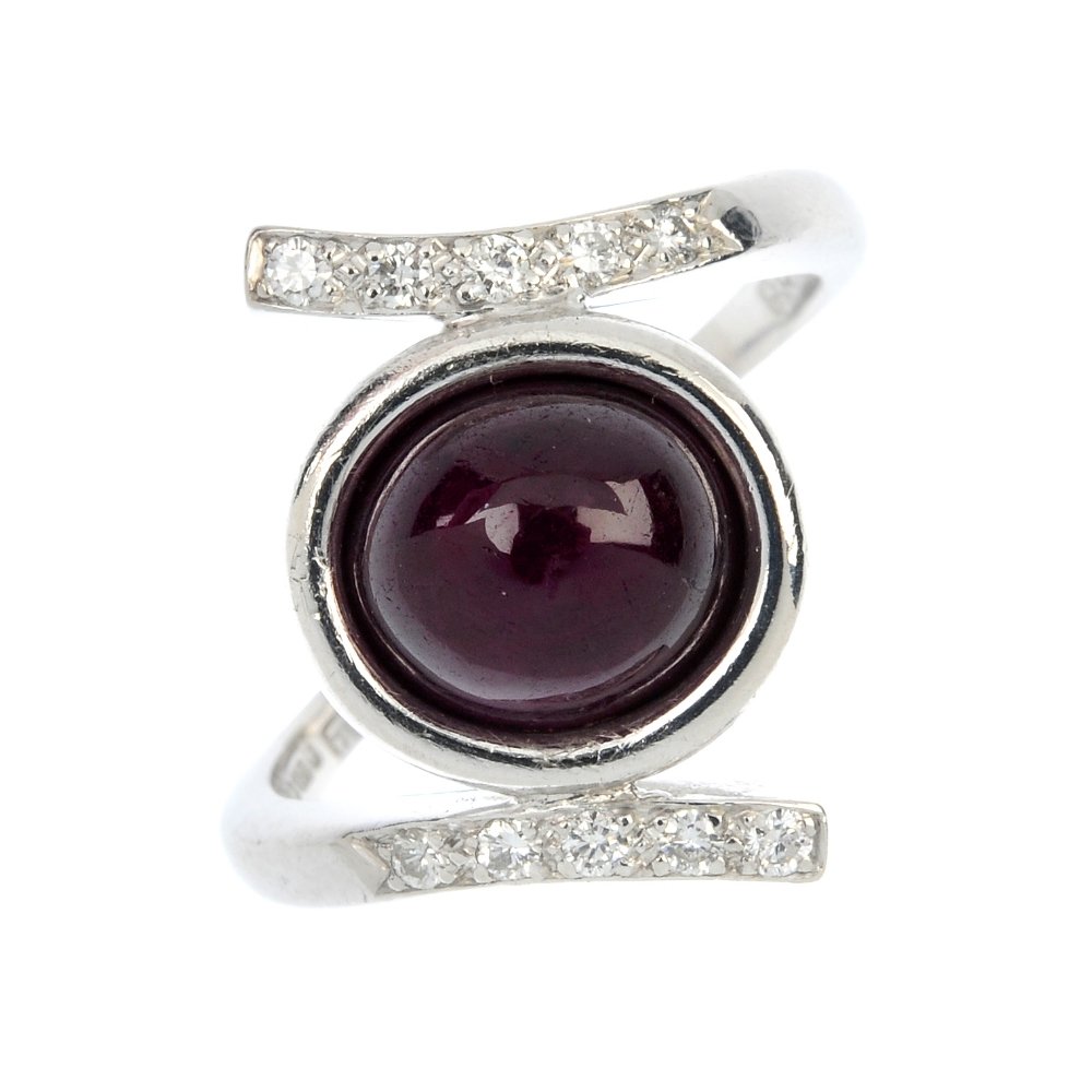 ANDREW GRIMA - an 18ct gold ruby and diamond dress: ANDREW GRIMA - an 18ct gold ruby and diamond dress ring. Of asymmetric design, the circular ruby cabochon, within an extended collet setting, to the brilliant-cut diamond crossover shoulders and taper