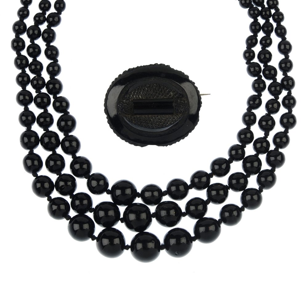 A selection of jewellery, to include a jet brooch.: A selection of jewellery, to include a late 19th century carved jet brooch, two early 20th century paste buckles, a large plastic comb, a late 19th century blue enamel sword pin, together with four fu