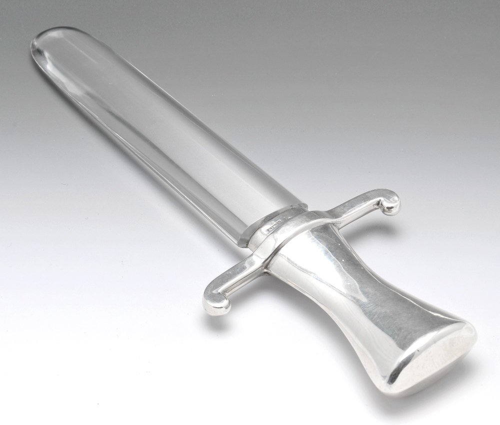 An Edwardian silver and glass paper knife.: An Edwardian silver and glass paper knife modelled as a sword, the glass blade, to the silver tapered grip and crossguard. Hallmarked Birmingham, 1909. Length 7 3/7 inches (18.8 cm).