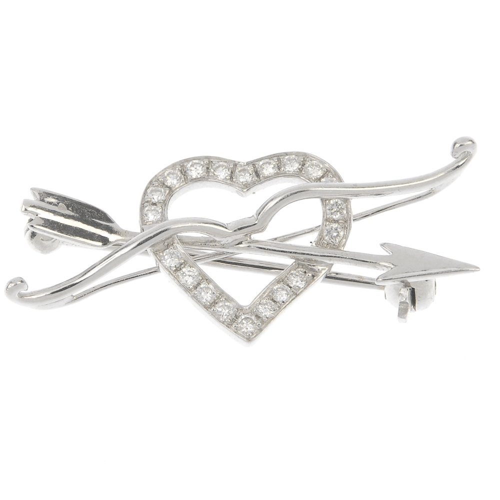 An 18ct gold diamond bow and arrow heart brooch, by: An 18ct gold diamond bow and arrow heart brooch. Designed as a brilliant-cut diamond undulating heart, interwoven with crossed bow and arrow motif. Maker's mark for Mappin & Webb. Estimated total diam