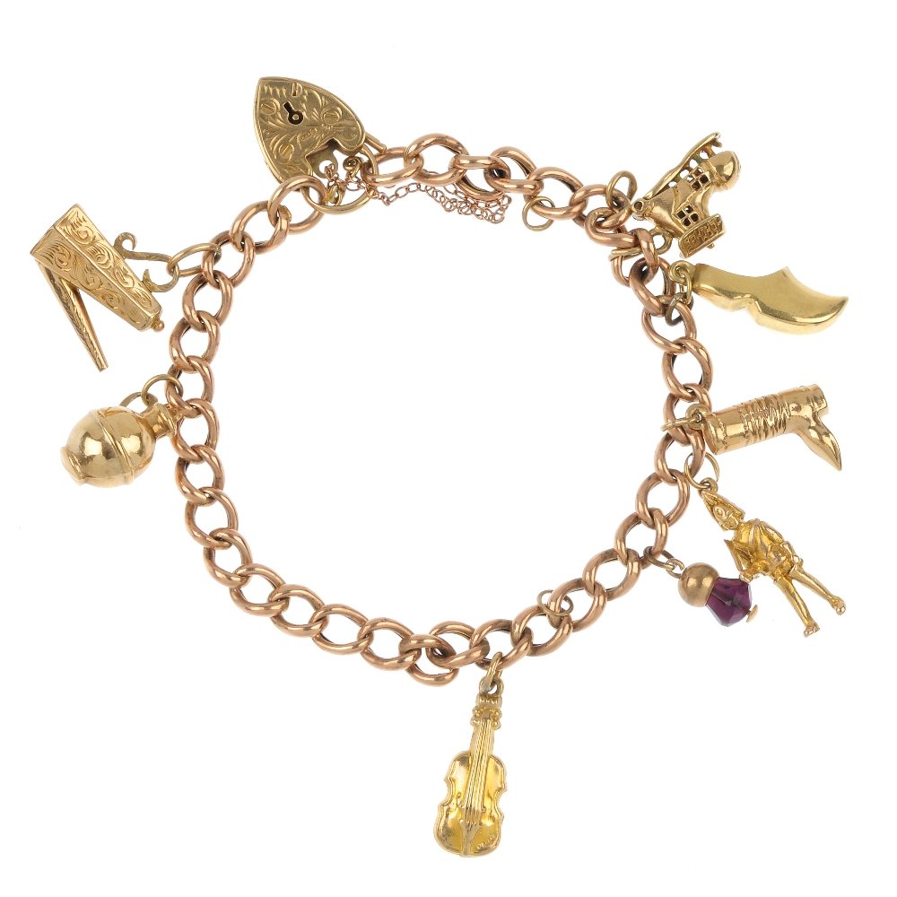 A 9ct gold charm bracelet.: A 9ct gold charm bracelet. The early 20th century curb-link chain, suspending eight charms, to include a coffee pot, a hinged man in a shoe charm and a violin charm, to the 9ct gold padlock clasp. Len