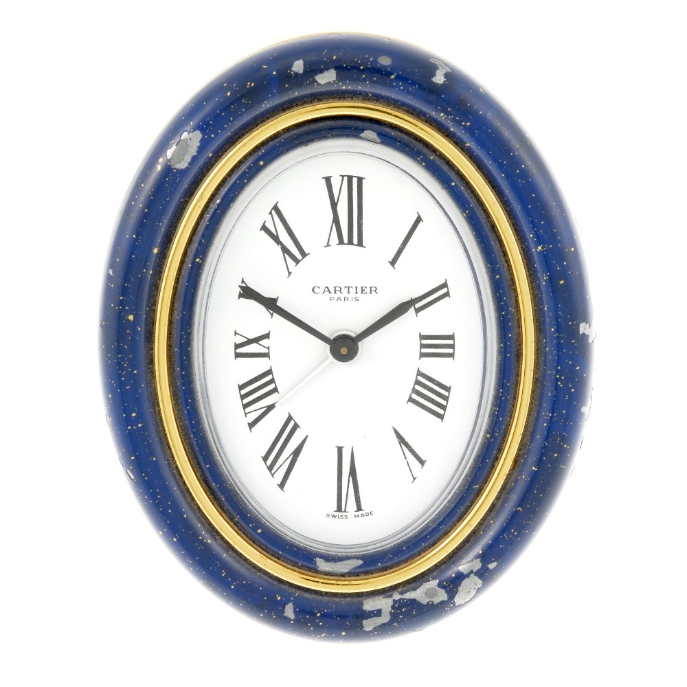 An alarm travel clock by Cartier.: An alarm travel clock by Cartier. Numbered 7509 10281. Manual wind movement. White dial with Roman numeral hour markers. Blue enamel and gold plated case. 72mm.