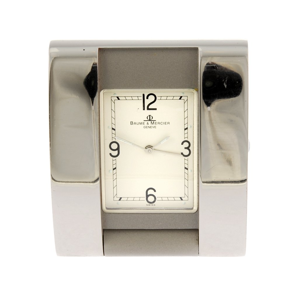 An alarm travel clock by Baume & Mercier: An alarm travel clock by Baume & Mercier. Numbered 8001290. Quartz movement. Silvered dial with quarterly applied Arabic numerals. Stainless steel case. 46mm.