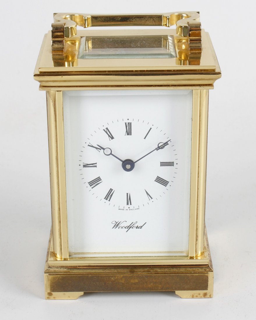 A reproduction brass cased carriage clock: A reproduction brass cased carriage clock, the white Roman dial with Breguet hands, marked Woodford, the black plate engraved Made in England, and seven jewels, 6.25" (15.75cm) height to top of carry