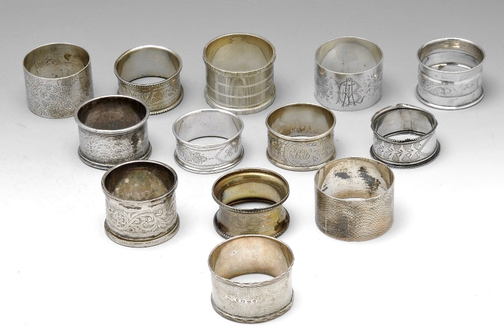 A selection of napkin rings.: A selection of thirteen silver napkin rings of various styles mostly with foliate engravings and with personal engravings. Various hallmarks and makers. Gross weight 9.1 ozt (284 grams). (13).