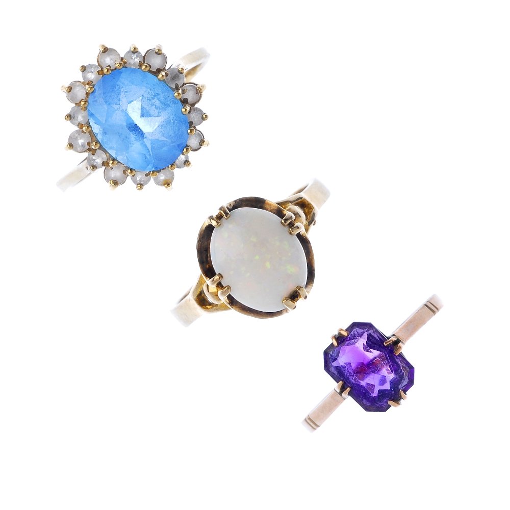 A selection of three gem-set rings.: A selection of three gem-set rings. To include an early 20th century 9ct gold rectangular-shape amethyst single-stone ring, a 9ct gold oval-shape blue topaz and colourless paste cluster ring, and an o
