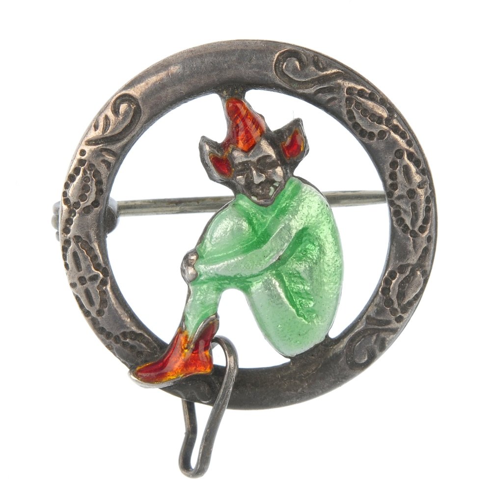BERNARD INSTONE - an enamel brooch.: BERNARD INSTONE - an early 20th century silver enamel brooch, designed as a green and red enamel sitting imp, within a circular panel surround, together with a further purple enamel imp brooch. First