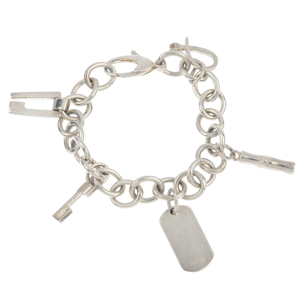 GUCCI - a charm bracelet.: GUCCI - a charm bracelet, the belcher-link chain, suspending a series of five charms, to the lobster-claw clasp. Maker's marks for Gucci. Length 19.7cms. Weight 35.1gms.