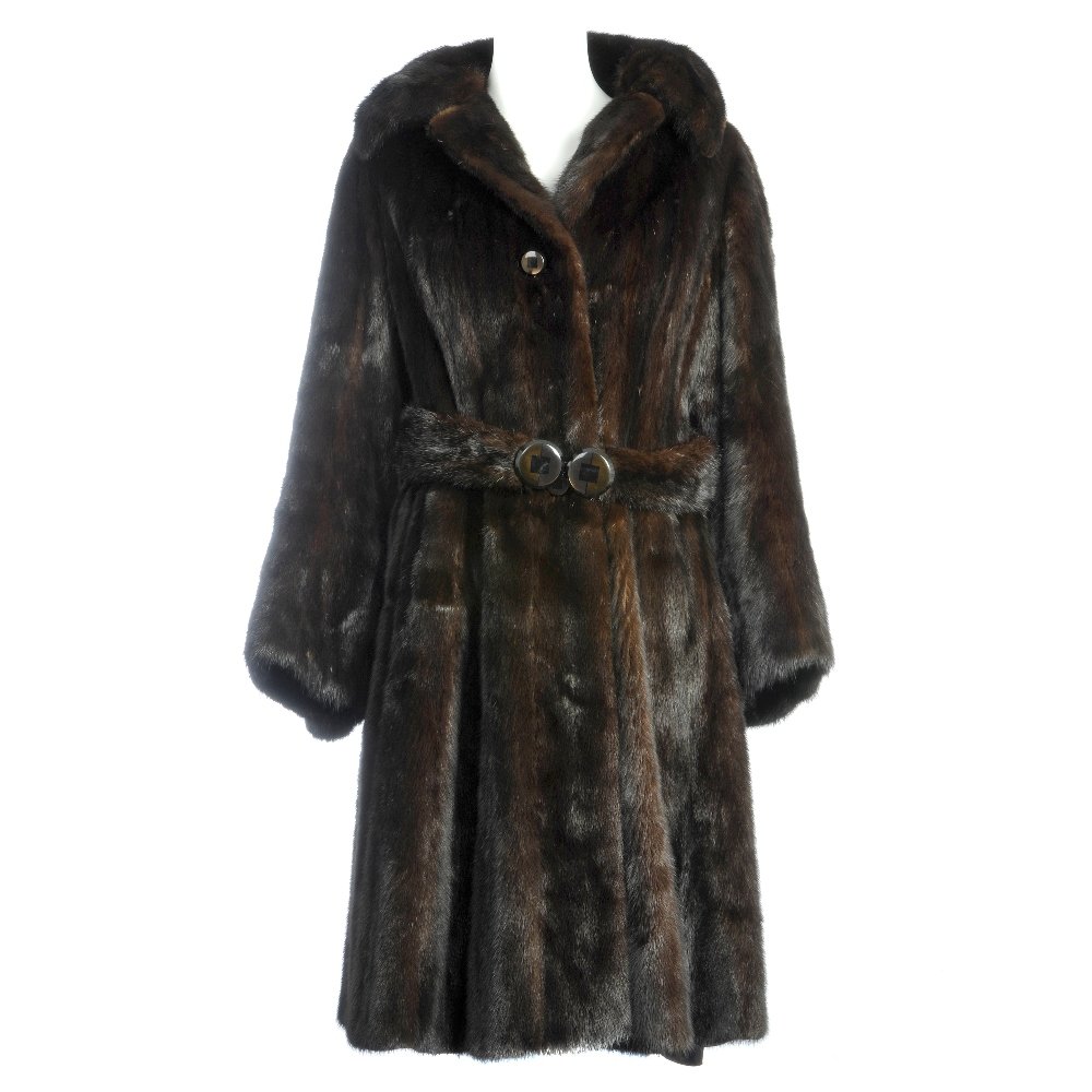 A dark ranch mink coat: A full length dark ranch mink coat, with a fitted waist, notched lapel collar, bell bottom cocktail cuffs, hook and eye clip fastenings with front button feature, optional extendable half belt to full