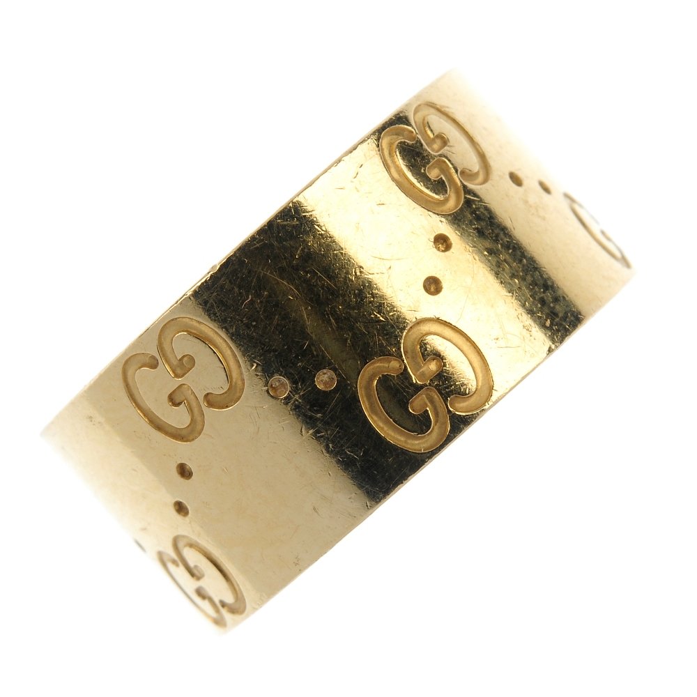GUCCI - an 18ct gold 'Icon' band ring.: GUCCI - an 18ct gold 'Icon' band ring. The band with impressed double G motif and dimple spacers. Signed and numbered Gucci, 1695M1. Hallmarks for London. Weight 8.7gms.
