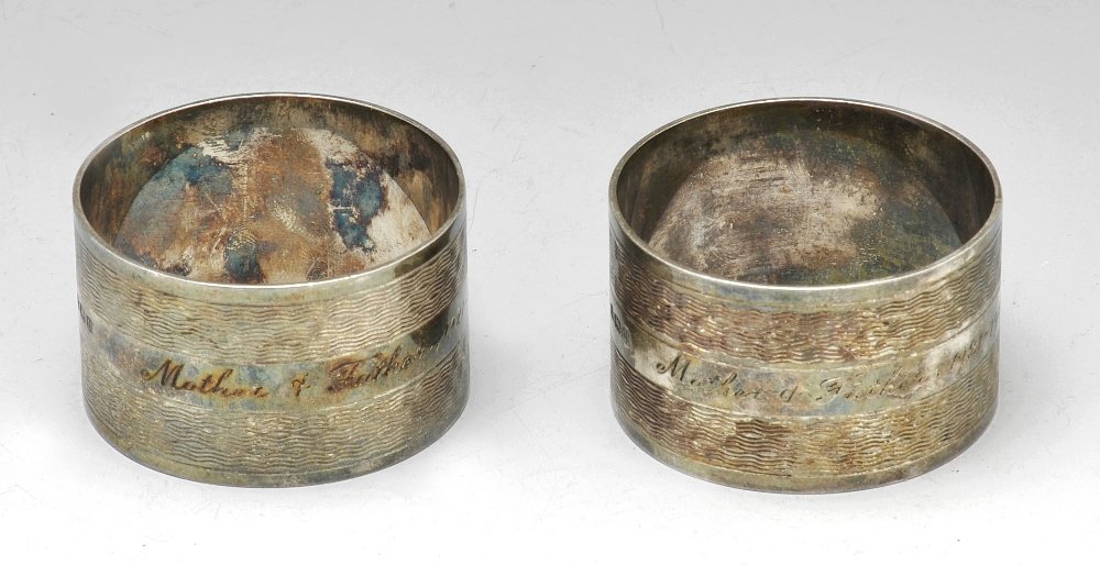 A selection of slver napkin rings.: A pair of 1940's silver napkin rings of circular form, with engine turned decoration and personal dedication inscription to the central band, hallmarked Arnold E Williams, Birmingham 1944. Together wi