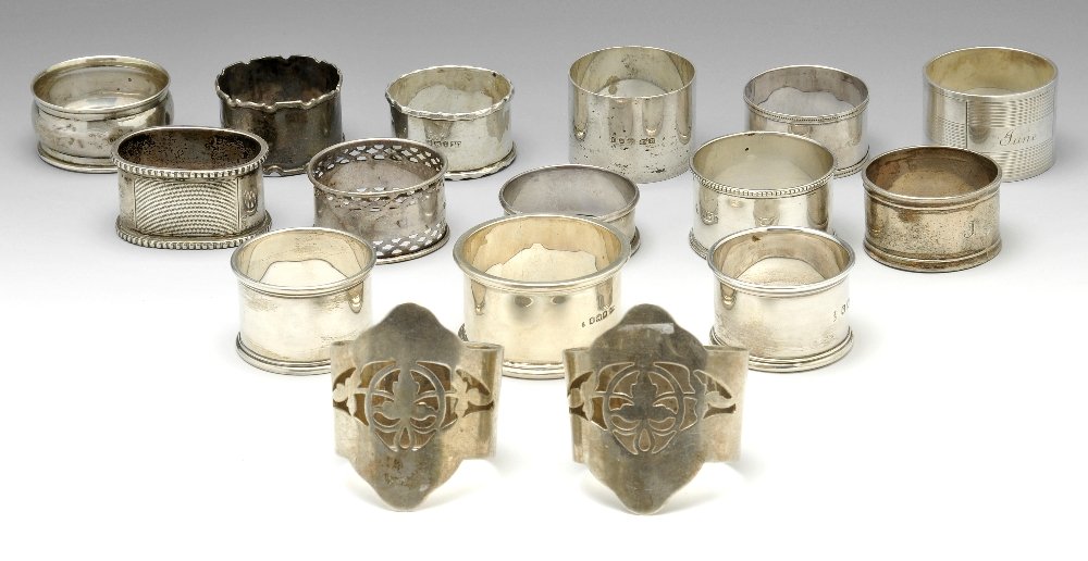 A selection of sixteen silver napkin rings.: A selection of sixteen silver napkin rings of various styles, to include a foliate pierced oval pair and a plain circular pair, many of the other examples with personal engravings. Various hallmarks a