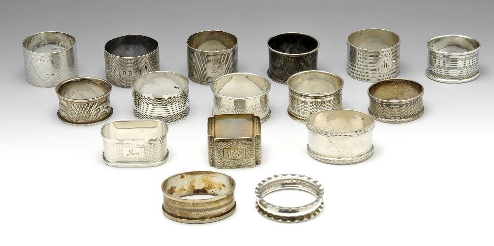 A selection of sixteen silver napkin rings.: A selection of sixteen silver napkin rings of various styles, mostly with engine turned decoration and many with personal engravings. Various hallmarks and makers, one example marked 'Silver' only. Gr