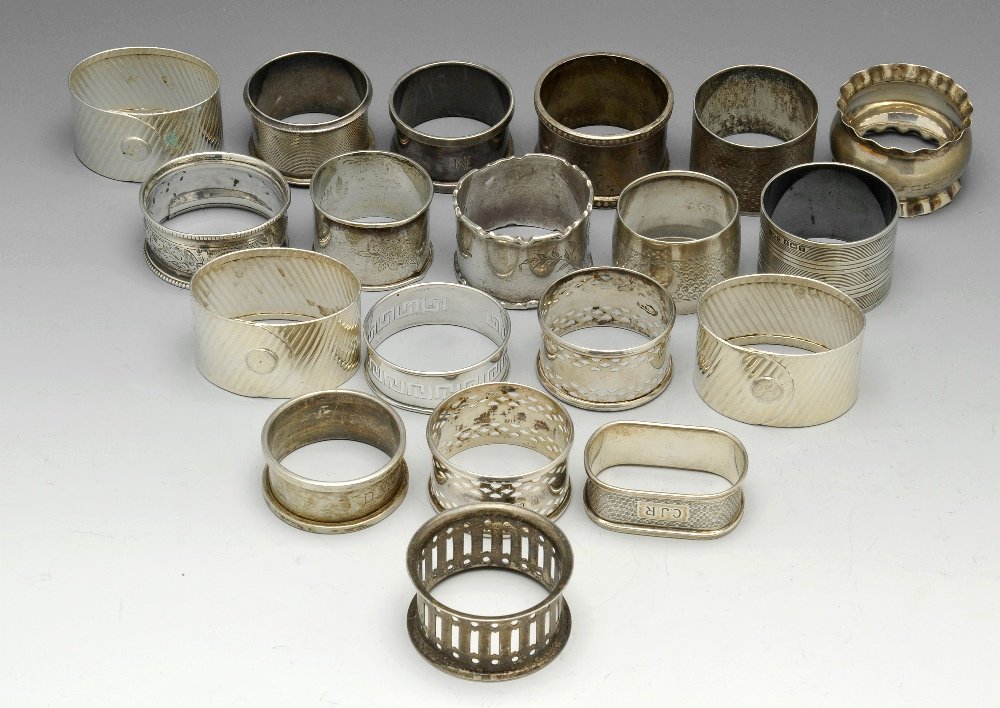 A selection of nineteen assorted napkin rings.: A selection of nineteen assorted napkin rings of various shapes and styles, to include pierced, floral engraved and engine turned examples, some with personal engravings. Various hallmarks and makers 