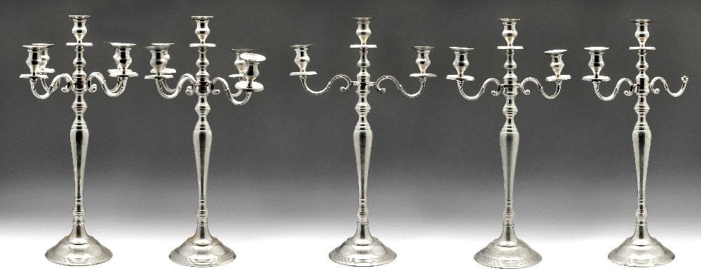 A group of five silver plate candelabras.: A modern set of five large silver plated candelabras, of baluster form with reeded border and supporting either two or four scrolling branches. Height measuring 23 1/2 inches (60 cm).