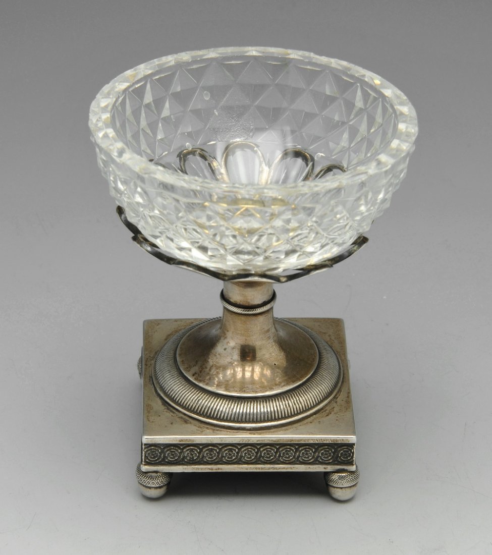 An early nineteenth century Flemish import silver and: An early nineteenth century Flemish import silver and glass open salt, the cut glass bowl raised on pedestal support and square base, upon four further acorn feet. Import marks (1814-1831 for Belgium.