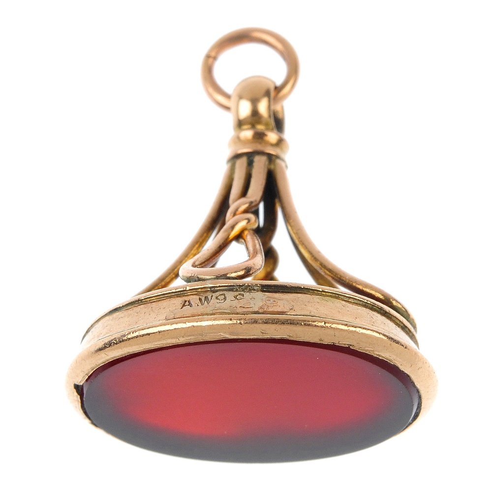 An early 20th century gold carnelian fob.: An early 20th century gold carnelian fob. The oval-shape carnelian to the stylised pedestal. Length 3cms. Total weight 6gms.