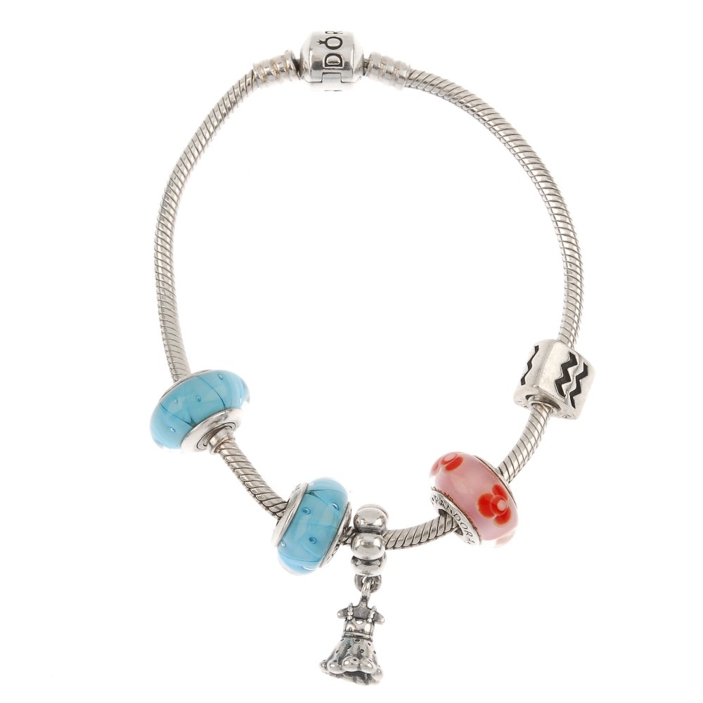 PANDORA - two silver charm bracelets and charms.: PANDORA - two silver charm bracelets and charms. Two snake-link bracelets, suspending eleven charms to include an enamel floral charm, a dress and three glass charms. Maker's marks for Pandora. Bracel