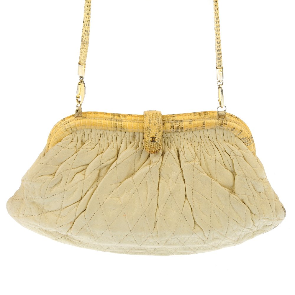 CHANEL - a vintage handbag: CHANEL - a vintage handbag. Designed with a cream quilted leather exterior, lizard skin trim and detachable strap. Length measures 27cms. With original dust bag.