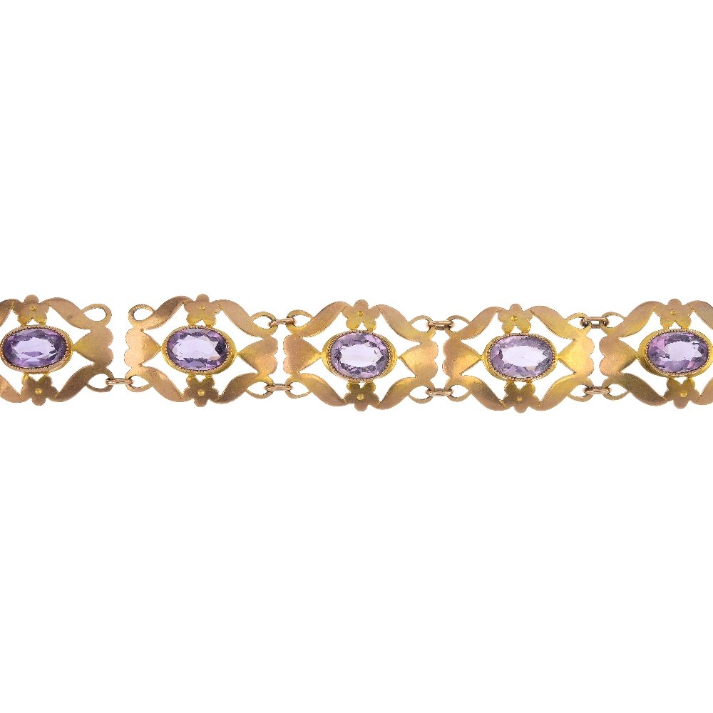 An Edwardian 9ct gold amethyst bracelet.: An Edwardian 9ct gold amethyst bracelet. Designed as a series of oval-shape amethysts, each within an openwork surround, to the padlock clasp. AF. Hallmarks for Birmingham, 1902. Length 18cms. Weight 