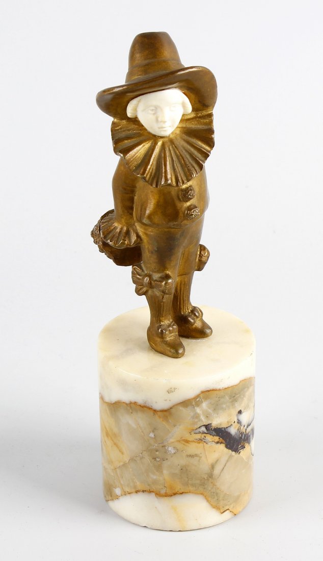 An Art Deco bronze and ivory figure: An Art Deco bronze and ivory figure, modelled as a young pierrette girl holding bouquet of flowers, stood upon circular marble plinth, 7" (17.5cm) high.