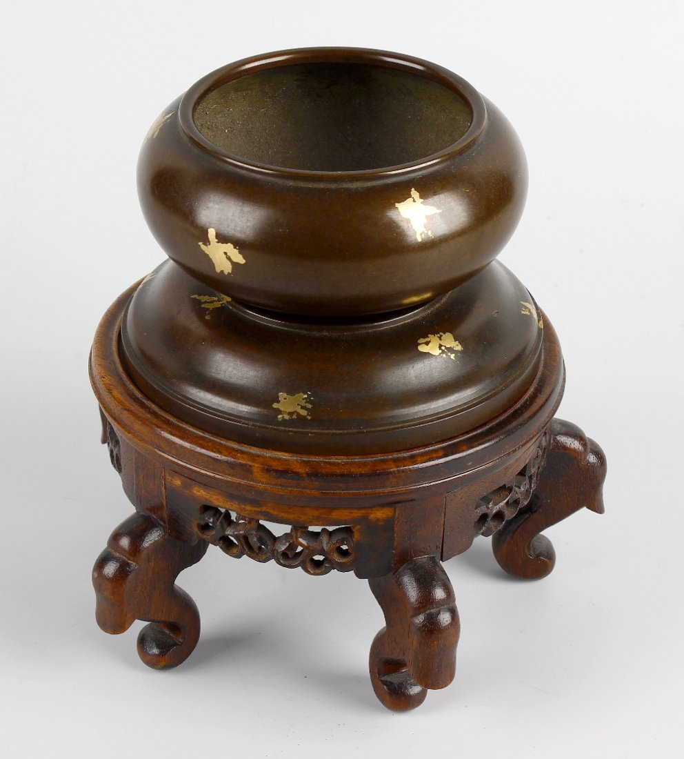 A Chinese gold splash bronze censer: A Chinese gold splash bronze censer, the bowl of squat form with seal mark beneath, above conforming domed support, the whole raised upon pierced hardwood base on five scroll feet, 6" (15cm).