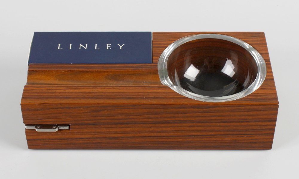 A Linley rosewood ashtray: A Linley rosewood ashtray, the whole of santos rosewooda with inset glass dish, cigar and match box setting, and concealed cigar cutter, marked 'Linley', 8.75 x 2.25" x 4" (22cm x 6cm x 10cm).