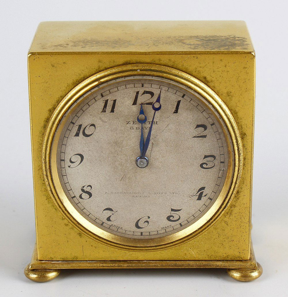 An early 20th century Zenith travel clock: An early 20th century Zenith travel clock, the Arabic dial having blued steel breguet hands, timepiece movement, in plain gilt brass case of square form raised upon four bun feet, 2.25" (6cm) high, in