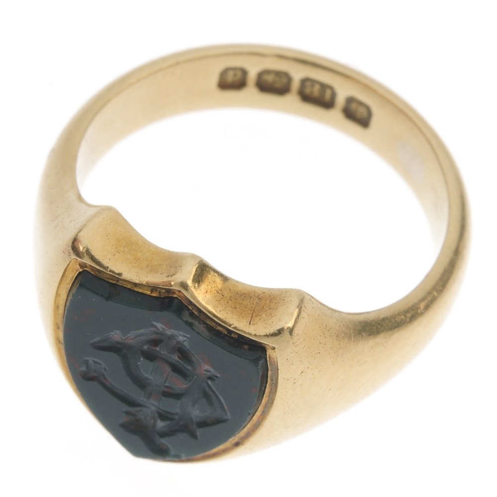 A gentleman's Edwardian 18ct gold bloodstone signet: A gentleman's Edwardian 18ct gold bloodstone signet ring. The shield-shape bloodstone panel, with engraved monogram, to the tapered sides. Hallmarks for Birmingham, 1903. Weight 10.1gms.