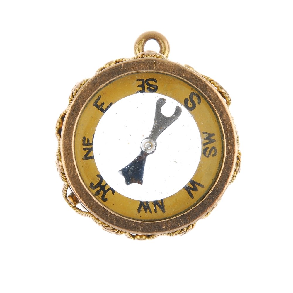 A 1920s 9ct gold compass fob.: A 1920s 9ct gold compass fob. The compass, within an undulating rope-twist border. Hallmarks for Birmingham, 1924. Length 2.2cms. Weight 7.5gms.