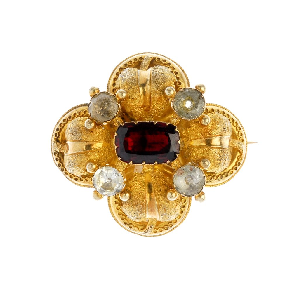 A mid 19th century gold gem-set brooch.: A mid 19th century gold gem-set brooch. The foil-back cushion-shape garnet and circular-shape beryl quatrefoil, with textured foliate and cannetille halo scalloped surround. Length 3.7cms. Weight 7.4g