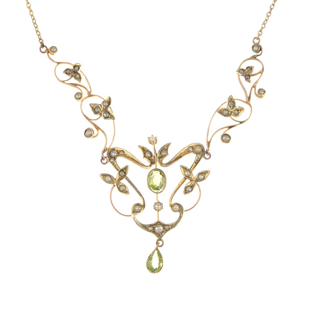 An early 20th century 9ct gold paste and split pearl: An early 20th century 9ct gold paste and split pearl necklace. The oval-shape green garnet-topped-doublet, within a split pearl floral and scroll surround, suspending a pear-shape green paste, to the