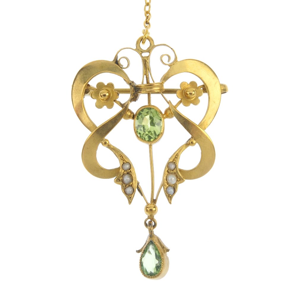 An early 20th century 9ct gold peridot, split pearl and: An early 20th century 9ct gold peridot, split pearl and paste pendant. The oval-shape peridot, within a split pearl scroll and floral surround, suspending a replacement pear-shape green paste drop. Le