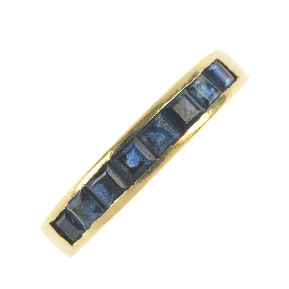 A sapphire half-circle eternity ring.: A sapphire half-circle eternity ring. The square-shape sapphire line, inset to the tapered band. Weight 3.2gms.