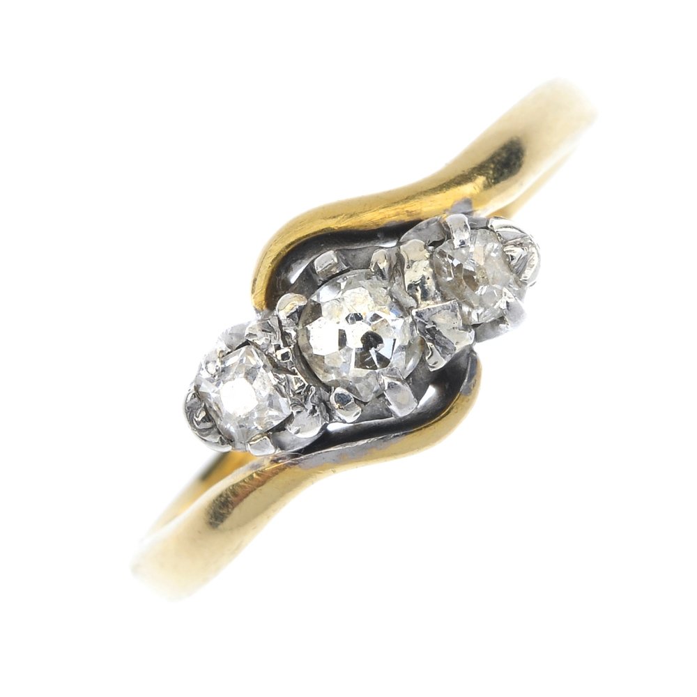A diamond three-stone crossover ring. (1 of 4)