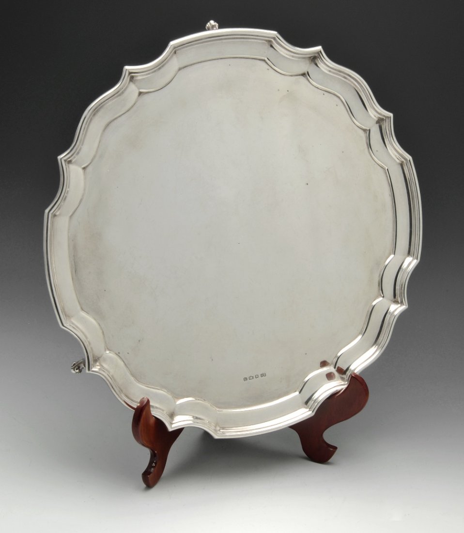 A mid 20th century silver salver, diameter 14 inches.: A mid-twentieth century silver salver of circular form, having a simple Chippendale style border to a plain centre and raised on three splayed and scrolled feet. Hallmarked Robert Pringle & Sons, Shef