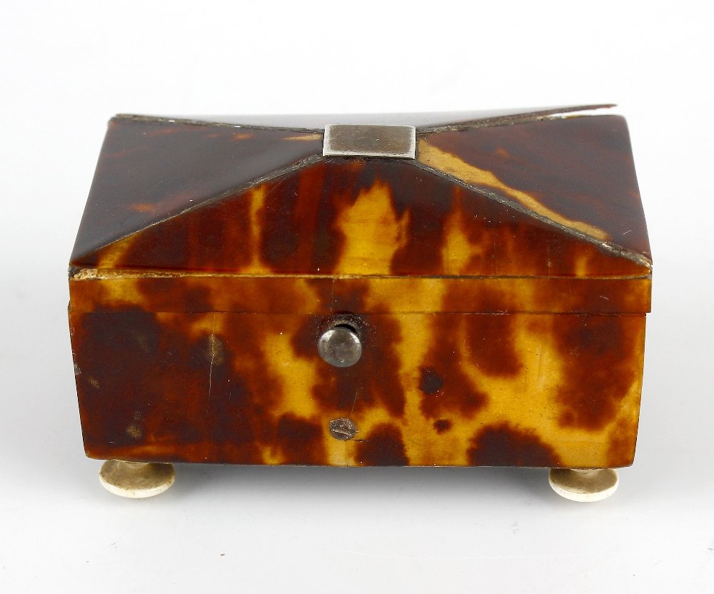 A 19th century tortoiseshell stamp- or thimble-case.: A 19th century tortoiseshell stamp- or thimble-case. In the form of a miniature sarcophagus tea caddy on four ivory bun feet, with internal label "THOS. LUND MAKER 57 Cornhill LONDON", 2" wide x 1.2" 