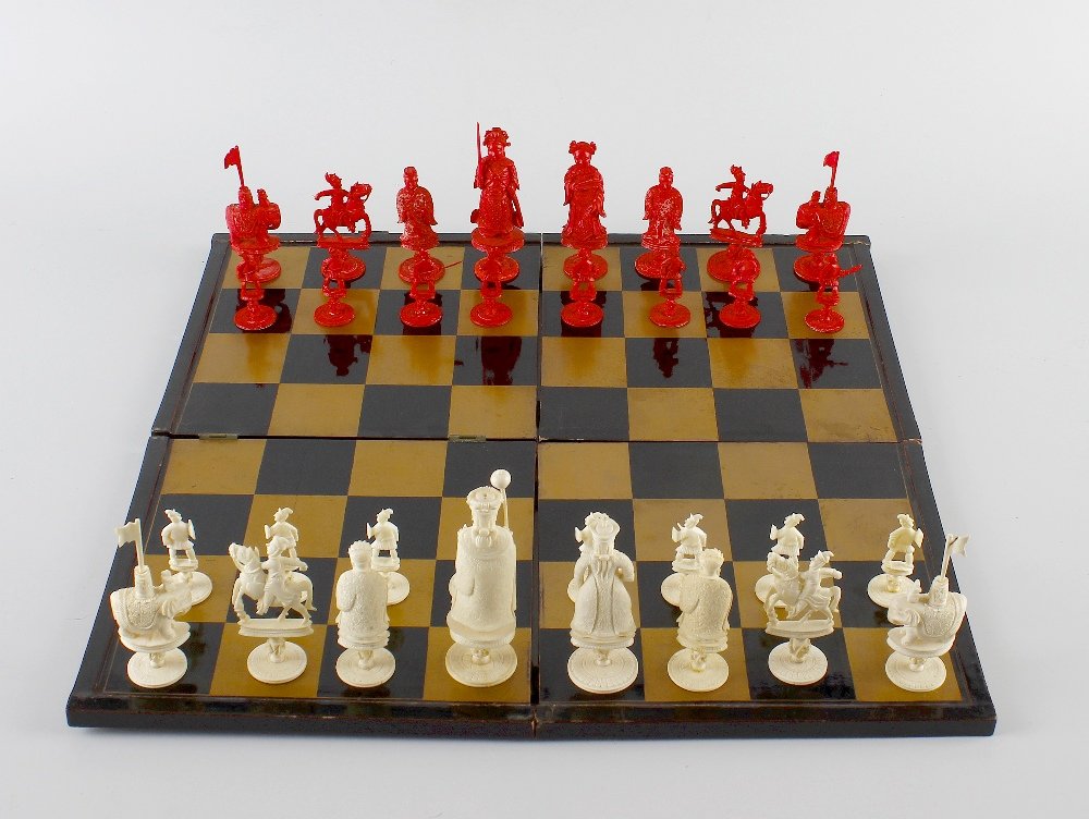 A Chinese carved ivory chess set.: A Chinese carved ivory chess set comprising red-stained and natural pieces, the kings and queens modelled as figures in traditional dress raised upon short knopped stem and circular base, he holding u