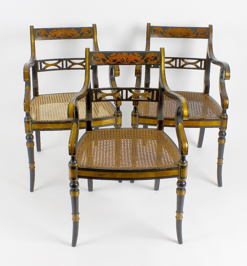 A 20th century Chinese black lacquer oval breakfast tab: A 20th century Chinese black lacquer oval breakfast table, having red and gilt scrolling boarder beneath a glass top, raised upon pedestal base terminating in four lion paw brass castors, 54" x 39" x 