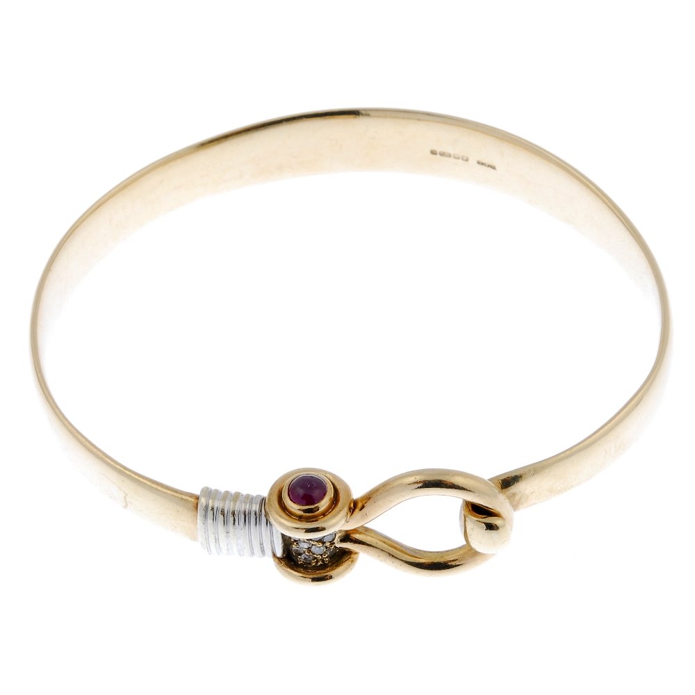 A 9ct gold diamond and ruby bangle. (1 of 2)