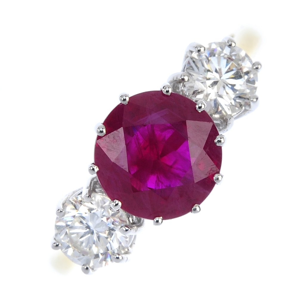 An 18ct gold ruby and diamond three-stone ring. (1 of 3)