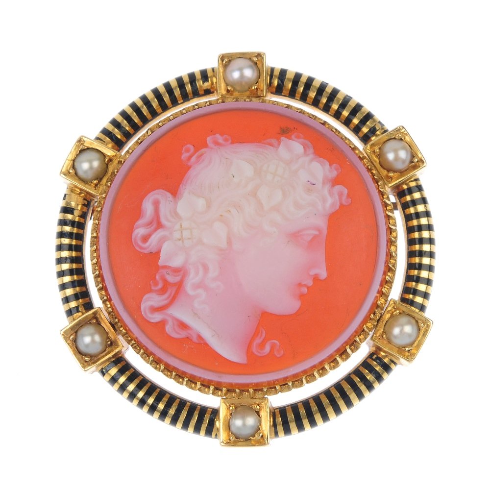 A hardstone cameo brooch.: A hardstone cameo brooch. The circular carnelian carved to depict a man in profile to the black banded enamel and seed pearl surround. Length 3.6cms. Weight 13.1gms.