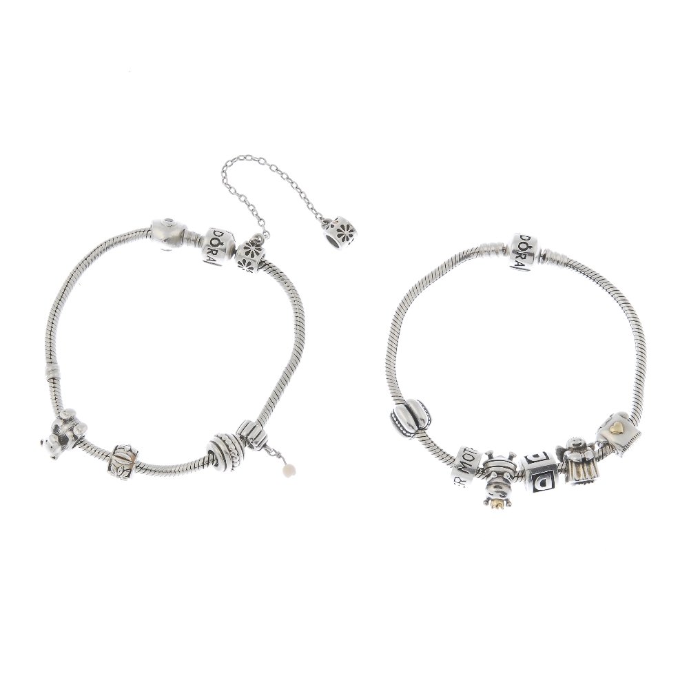 PANDORA - two charm bracelets.: PANDORA - two charm bracelets. The two snake-link bracelets, suspending a total of eleven charms and a safety-chain, to include a heart-shape charm with pink cubic zirconia, a bear charm and an initia