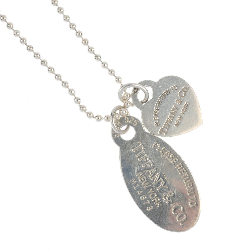 TIFFANY & CO. - a necklace and pendant.: TIFFANY & CO. - a necklace and pendant. The ball chain, suspending an oval-shape pendant with 'Please Return to Tiffany & Co New York, M14673' and personal engraving to the reverse, together with a he