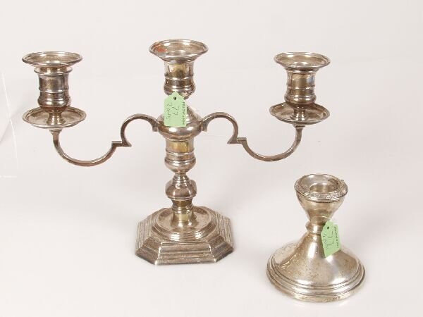 A three branch candleabra standing on a square st