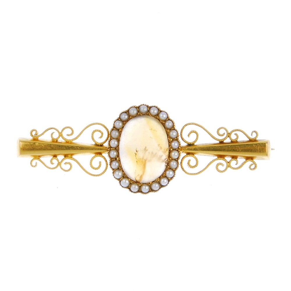 (540912-2-A) An early 20th century 15ct gold agate and: (540912-2-A) An early 20th century 15ct gold agate and split pearl brooch. The oval agate cabochon, within a split pearl surround, to the tapered and scrolling sides. Length 4.9cms. Weight 6.5gms.